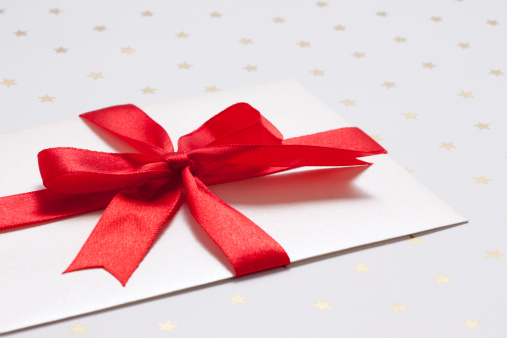 Gift card with red ribbon on white background.