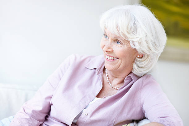 istock Smiling senior woman on sofa 184885020