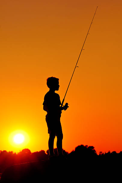 istock Little Boy Fishing At Sunset - III 184885147