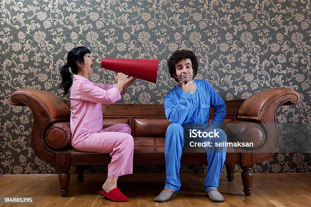 House Wife Shouting At Husband Via Megaphone On Sofa Stock Photo - Download Image Now