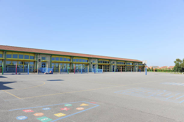 School building and playground Modern school building and playground - UK infant/junior school pupils of 5-10 years schoolyard stock pictures, royalty-free photos & images