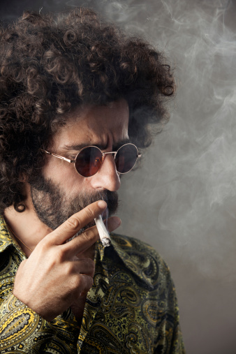 Man with big curly hair smoking marijuana