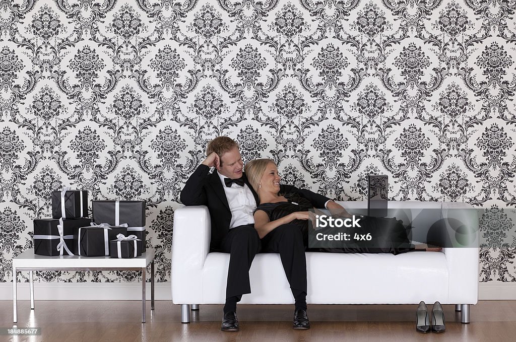 Couple de repos sur un canapé à l'aide d'un ordinateur portable - Photo de Adulte libre de droits