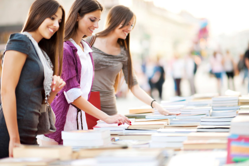 Three beautiful women buying books.