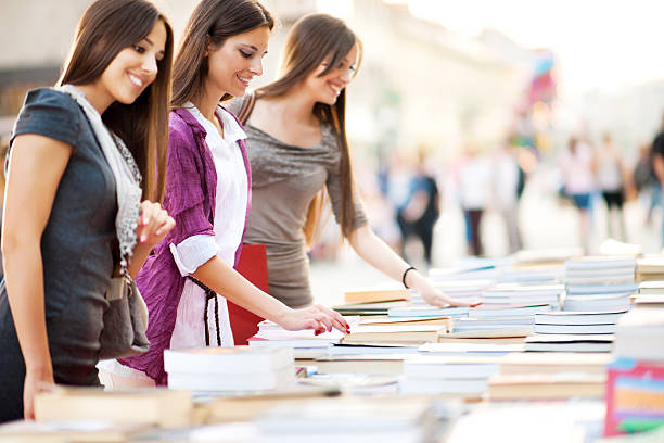 Young women buying books. Three beautiful women buying books. book bookstore sale shopping stock pictures, royalty-free photos & images