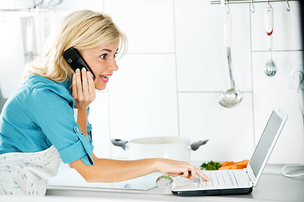 istock Beautiful woman talking on mobile and using laptop 184886316