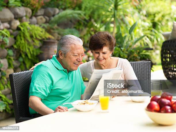 Foto de Casal Idoso Lendo Jornal Enquanto Come Cafédamanhã e mais fotos de stock de 60 Anos