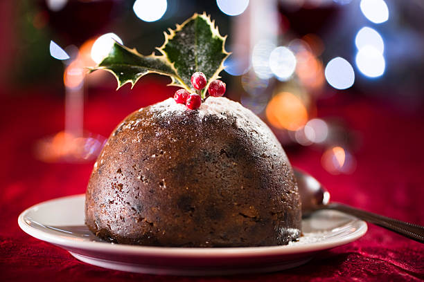 Christmas pudding with out of focus highlights Moody christmas pudding with out of focus highlights on red.  See also: christmas pudding stock pictures, royalty-free photos & images