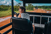 Young man on safari journey by off-road car in Sri Lanka.