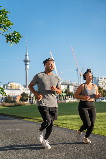 Young Maori couple in casual clothing running outdoor in  Auckland city, New Zealand.