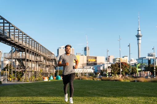 Young Maori couple in casual clothing running outdoor in  Auckland city, New Zealand.