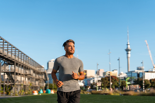 Young Maori couple in casual clothing running outdoor in  Auckland city, New Zealand.