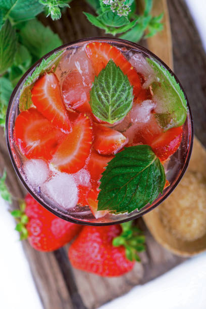 istock cocktail with fresh strawberries, mintand ice cubes over old white wooden table. 1848965436