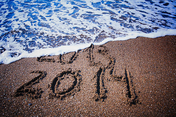 istock numbers on the beach is washing off by a wave 184898776