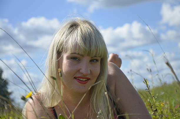 Ritratto di una giovane donna bionda mette nell'erba alta - foto stock