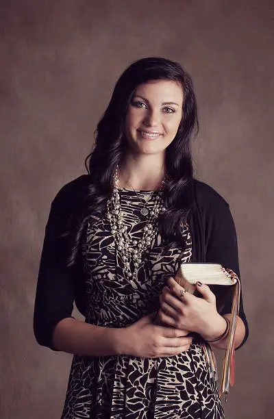An LDS missionary woman holding her bible and scriptures