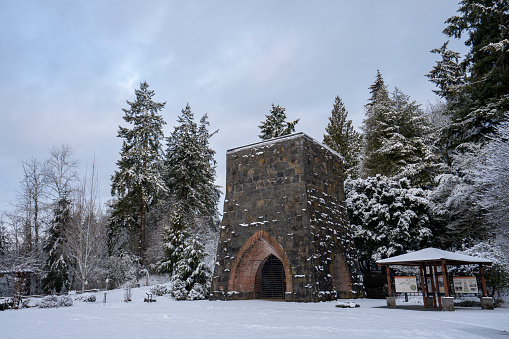 Lake Oswego, OR, USA - Feb 23, 2023: Restored remnants of the first Oregon Iron Company furnace in George Rogers Park in Lake Oswego, Oregon, viewed after heavy snowfall in winter.