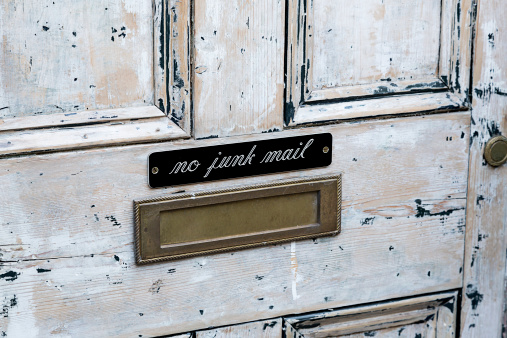 A distressed door with a No Junk Mail sign