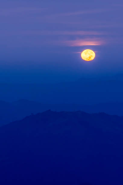 istock The full moon shines over blue mountains at dusk. 1849036358