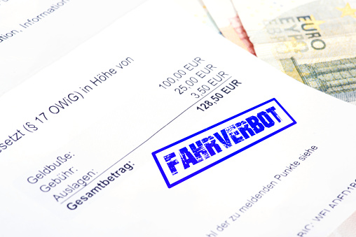 Ein Schreiben Bußgeldbescheid, Euro Geldscheine und Stempel Fahrverbot