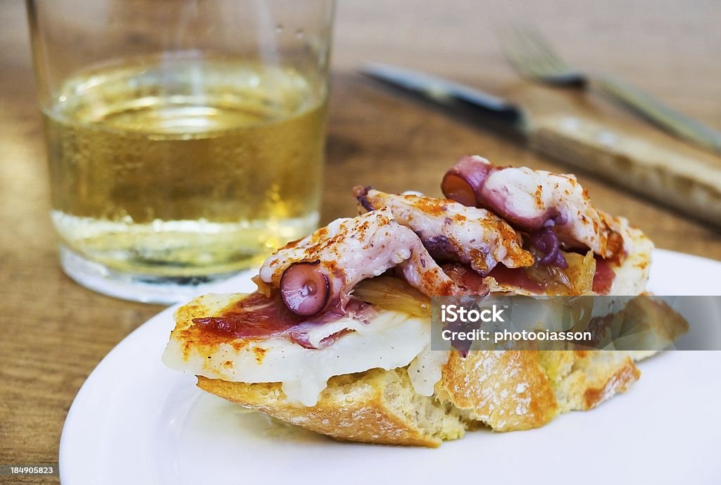 Typical spanish octopus pincho (Galician style) Typical spanish octopus pincho (Galician octopus style) in rustic table San Sebastian - Spain Stock Photo