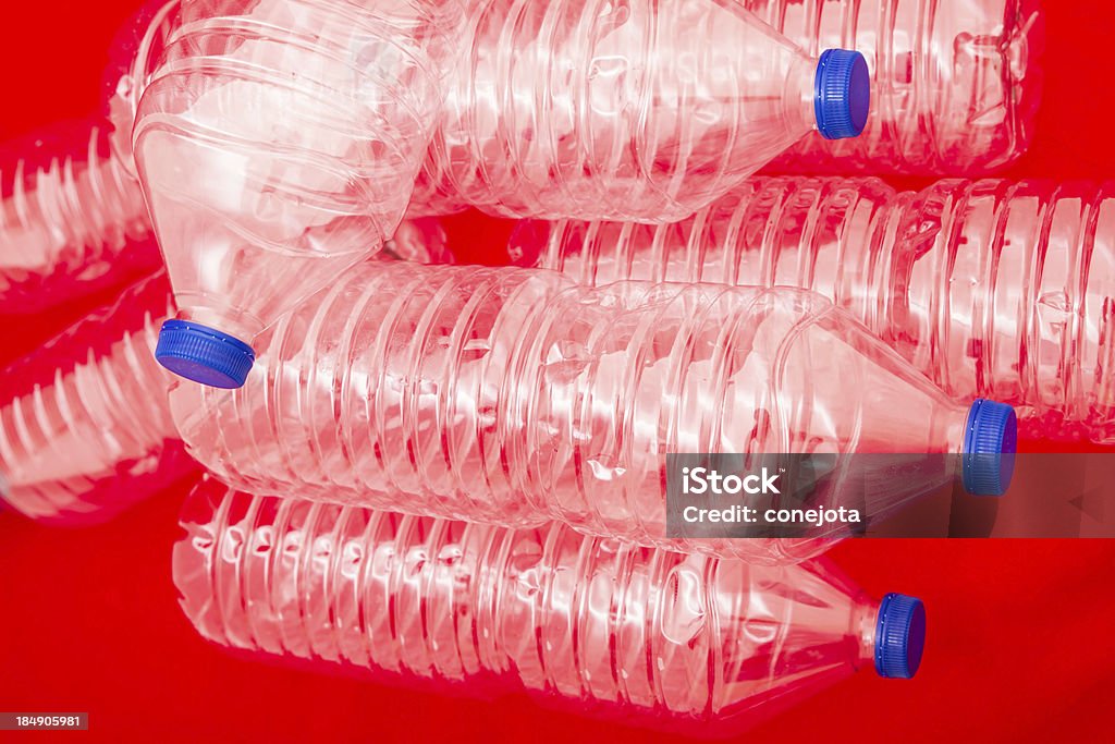 Bottles of water Empty bottles of mineral water, with a red background Blue Stock Photo