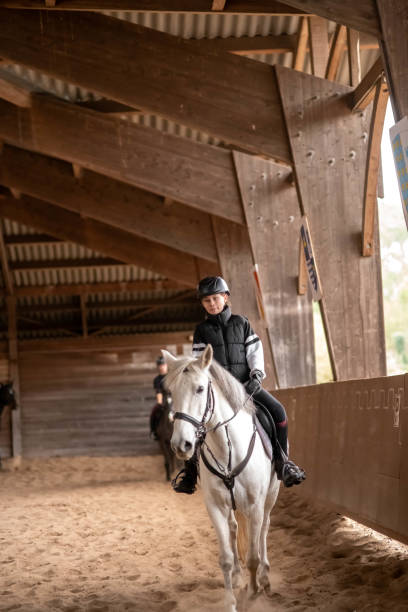 istock beautiful young girl on her white pony during her riding lesson 1849076281