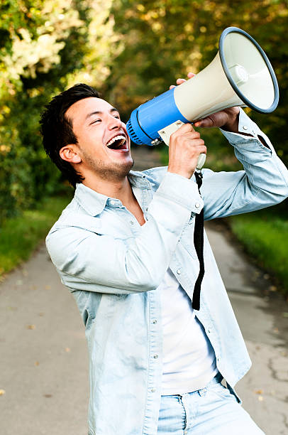 istock Young man screams into a megaphone 184908266