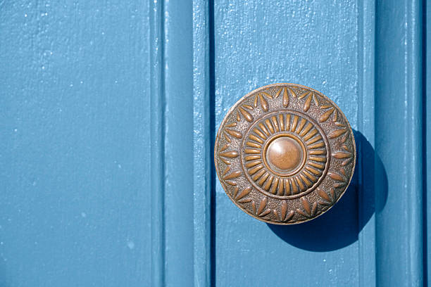 Old fashioned brass door knob on a heavenly blue door