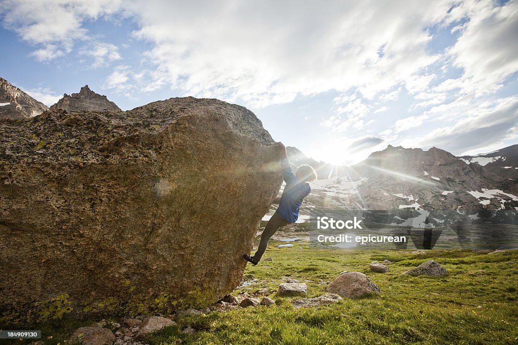Donna di arrampicata su roccia alpinista un problema di bouldering - Foto stock royalty-free di Abilità