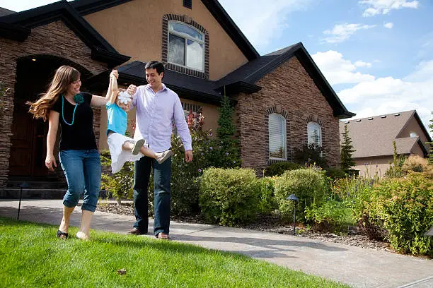 Photo of Cute Young Couple and Child with Beautiful Home