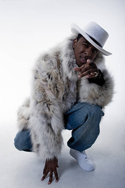 This Pimp Wants You! This Pimp wants you! Pointing & crouching with fur coat.* Studio floor and background are visible. pimp hat stock pictures, royalty-free photos & images