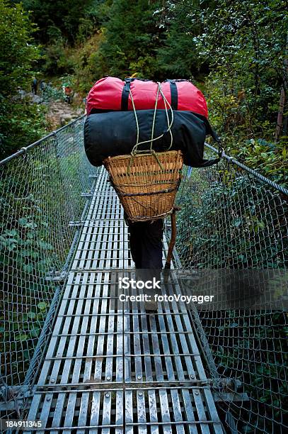 Sherpa Carrying Expedition Bags Over Rope Bridge Himalayas Nepal Stock Photo - Download Image Now