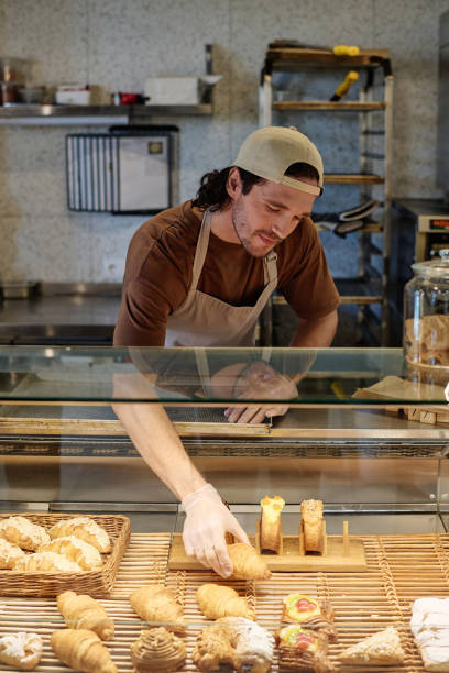 istock Cafe Employee Displaying Pastry for Sale 1849119178