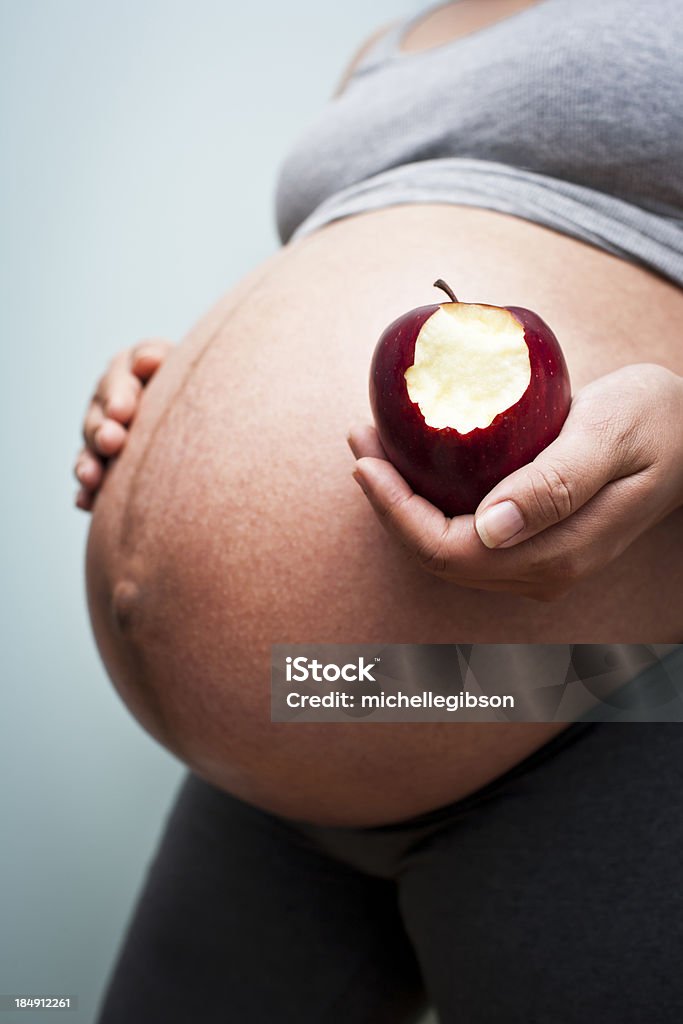 Pratiche di una donna incinta sana con una mela. - Foto stock royalty-free di Addome