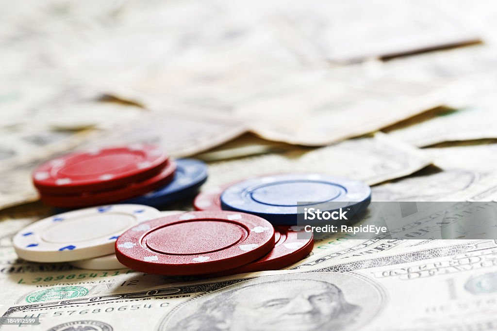 Gagner ou perdre de l'argent: Des jetons de casino sur dollars américains - Photo de Billet de banque libre de droits