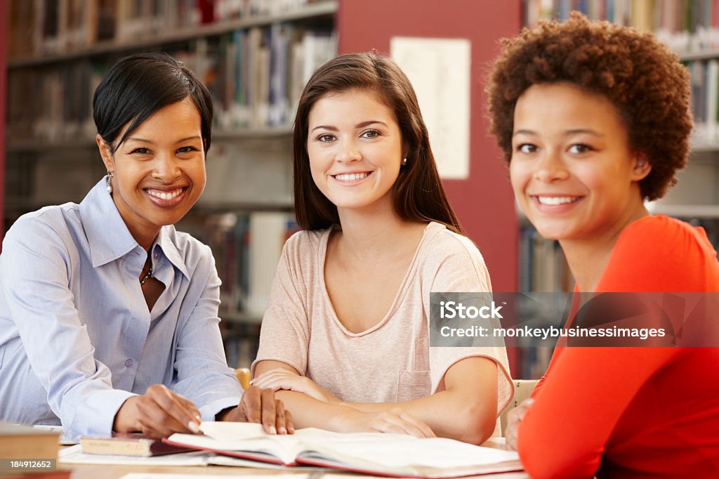 Zwei Studenten, die Arbeiten in der Bibliothek mit Lehrer - Lizenzfrei 14-15 Jahre Stock-Foto