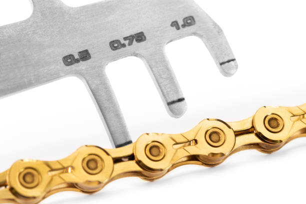 bicycle gold chain  with chain checker, chain wear tool closeup macro stock photo