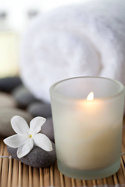 istock White burning candle with a flower and towel near 184912838