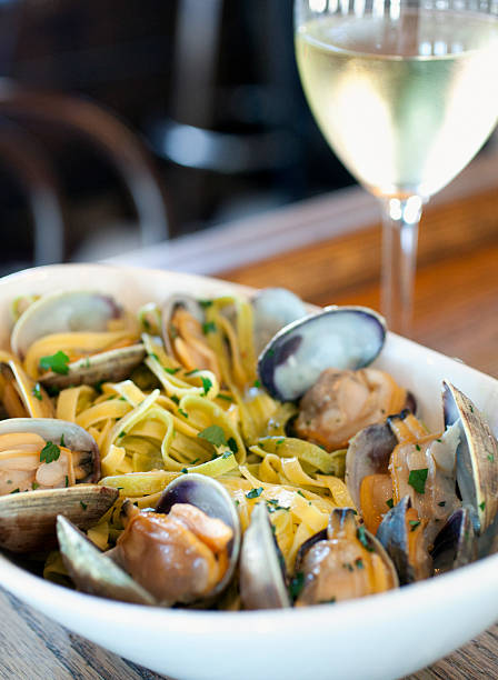 Linguine with clams A large bowl of linguine with clams served with a glass of wine fishermans wharf san francisco photos stock pictures, royalty-free photos & images