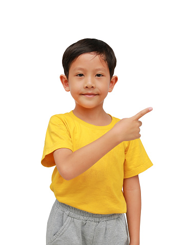 Smiling Asian little boy kid pointing up finger on white isolated studio background.