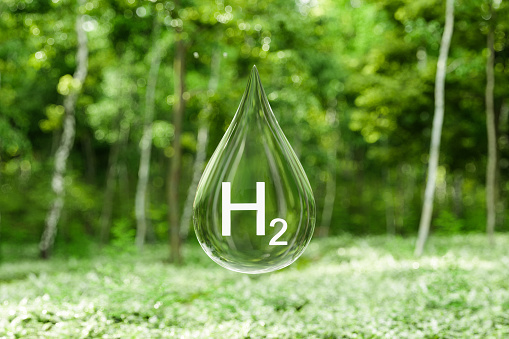 Close-up View Of Hydrogen Drop With Blurred Forest Background