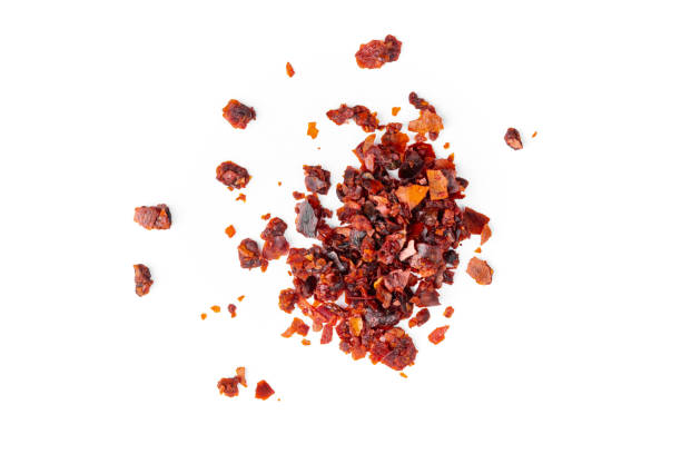 crushed red pepper flakes macro, isolated on white background closeup stock photo