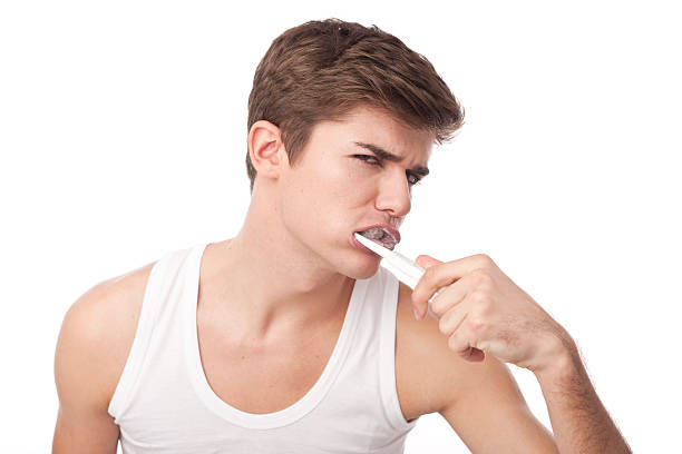 молодые мужчины, мыть его зубьев - brushing teeth healthcare and medicine cleaning distraught стоковые фото и изображения