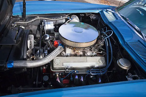 Car hood open showing Corvette engine. Horizontal.