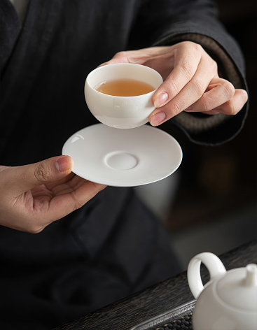 Make tea and enjoy it at home while relaxing. Minimalist art of making tea - A woman demonstrates a graceful tea-making style