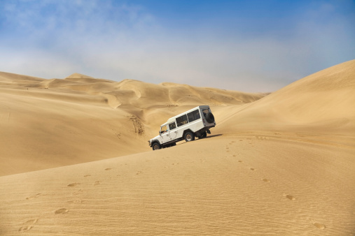 A four wheel drive vehicle descends the sand dunes between Walvis bay and Sandwich harbour.