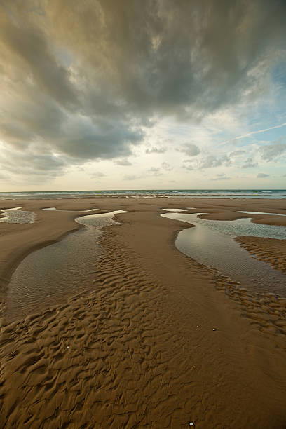 Empty beach in northern France under loomy sky