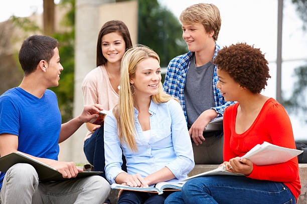 istock Multi racial student group sitting outdoors 184915300