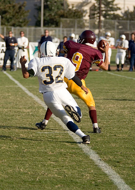 High School Football Quaterback getting a clutch throw completed Touchdown stock pictures, royalty-free photos & images